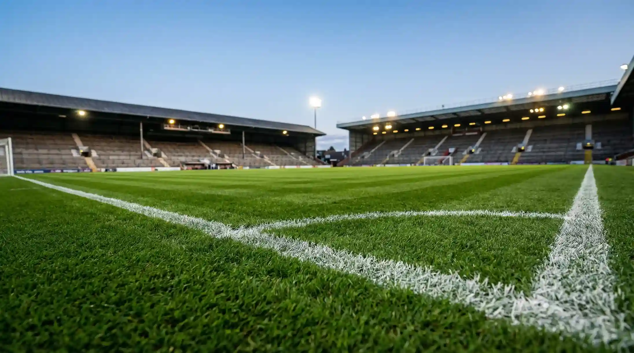 Campo da calcio inglese con erba verde perfetta sotto le luci dello stadio