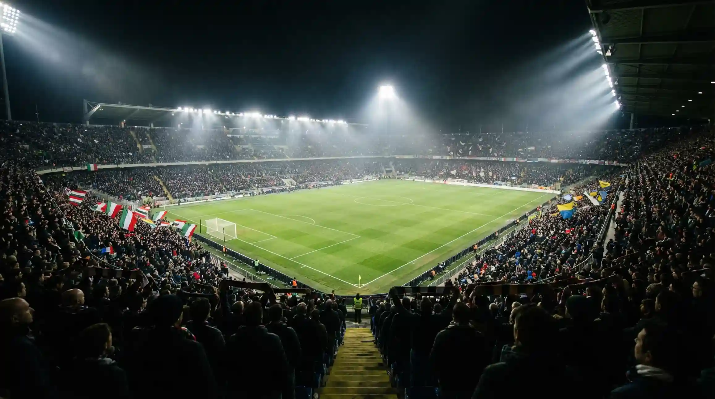 Stadio di calcio italiano pieno di tifosi durante una partita serale di Serie A